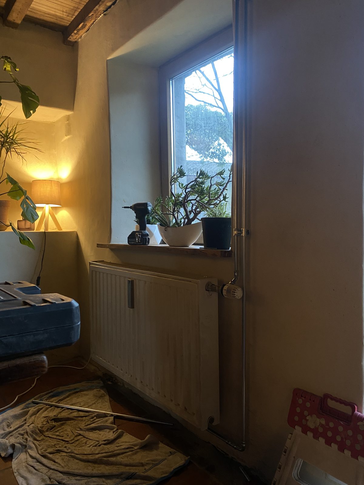 Radiateur sous une fenêtre dans un intérieur chaleureux au crépuscule